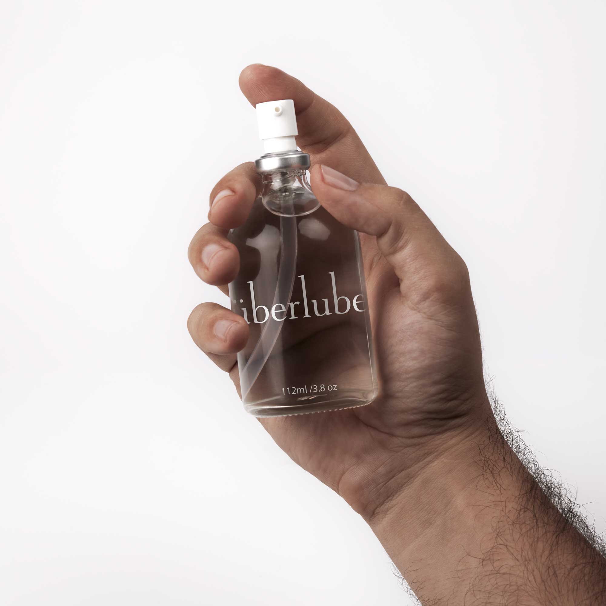 Überlube 112 ml bottle held in one hand, showing its size