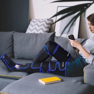 REATHLETE Air-C compression leg recovery boots wrapped around a person's legs and feet with handheld controller